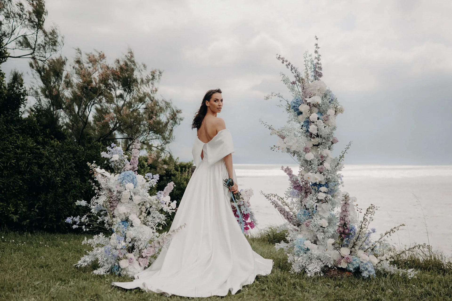 Robe de mariée et arche fleurie face à la mer